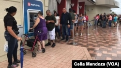 Residents of Ponce, Puerto Rico, line up at an ATM in hopes of getting some cash. More than a week after Hurricane Maria struck, residents are waiting in long lines to withdraw money and for gasoline.