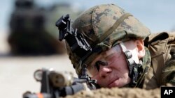 A U.S. Marine from the 31st Marine Expeditionary Unit aims his machine gun during the joint U.S.-South Korean military exercises, Foal Eagle, in Pohang, south of Seoul, South Korea, March 29, 2012.