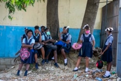 Student wait their turn to enter Lycee Marie Jeanne school on first day of school since the COVID-19 pandemic in Port-au-Prince, Haiti, Monday, Aug. 17, 2020. (AP Photo/Dieu Nalio Chery)