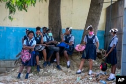Student wait their turn to enter Lycee Marie Jeanne school on first day of school since the COVID-19 pandemic in Port-au-Prince, Haiti, Monday, Aug. 17, 2020. (AP Photo/Dieu Nalio Chery)