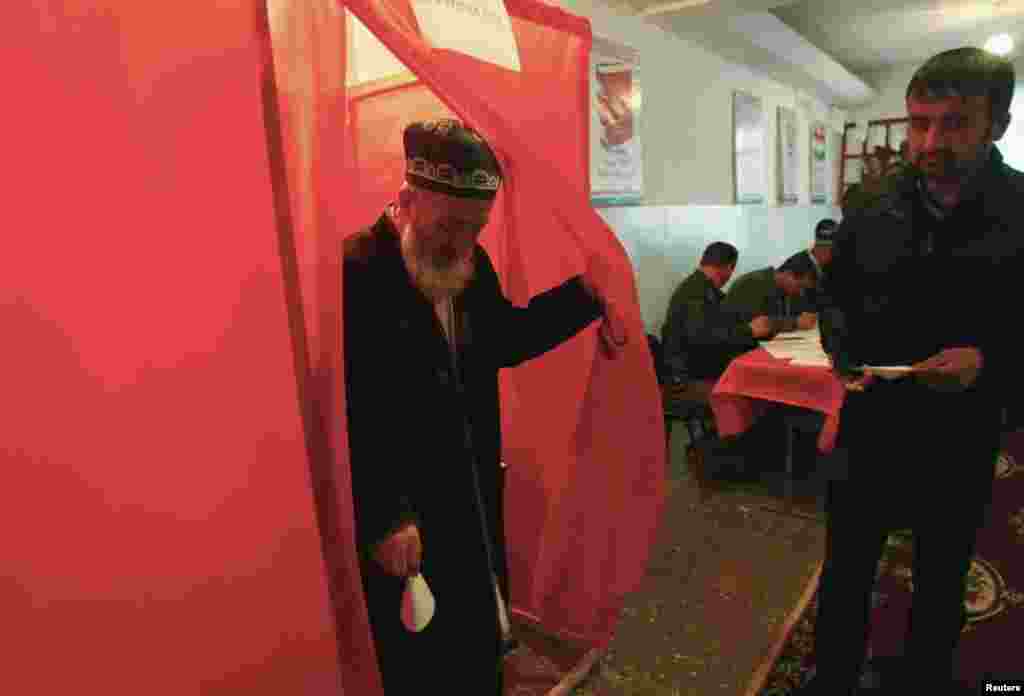 A man walks out of a voting booth at a polling station during the presidential election in Dushanbe, Nov. 6, 2013. 