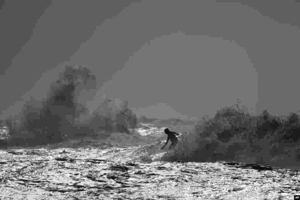 A surfer rides a wave in the Mediterranean sea in Netanya, Israel.