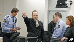 Anders Behring Breivik clenches his fist as he arrives in the courtroom for the first day of his trial in Oslo, Norway, April 16, 2012.