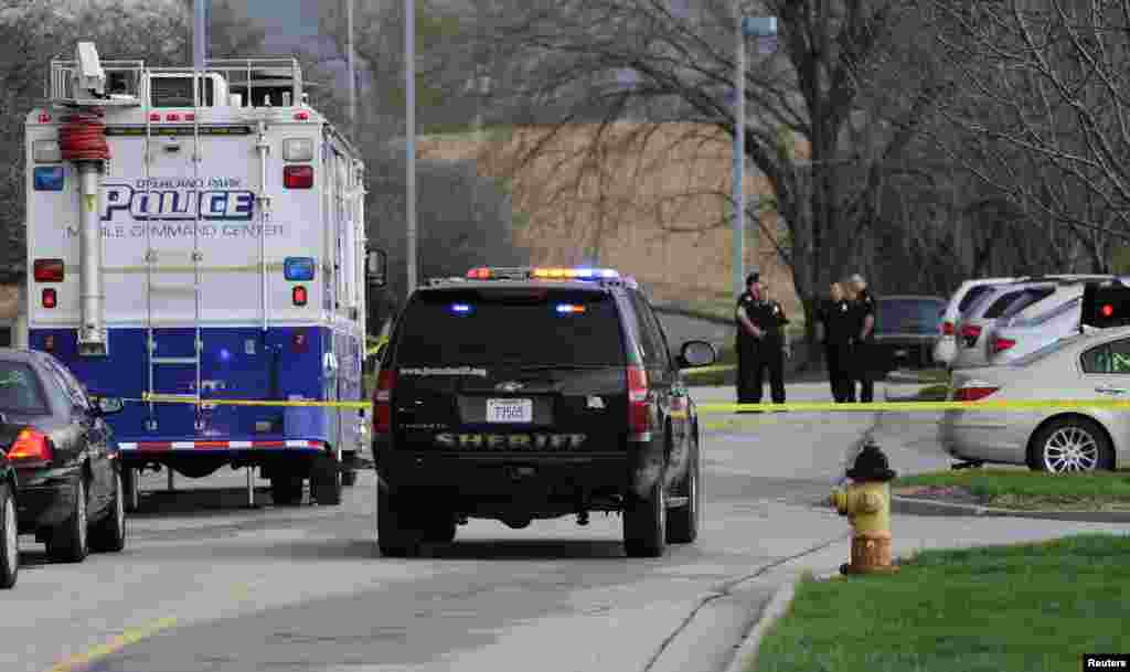 Police officers gather at the scene of a shooting at the Jewish Community Center of Greater Kansas City in Overland Park, Kansas, April 13, 2014. 