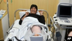 In this photo released by the government-run Bolivian Information Agency, Bolivia's President Evo Morales smiles after knee surgery to correct a soccer injury, in the recovery room of a clinic in Cochabamba, Bolivia, Sunday, June 12, 2016. 