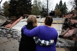 FILE - Neighbors comfort each other after the Camp Fire in Paradise, California, U.S. November 22, 2018. (REUTERS/Elijah Nouvelage)