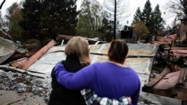 FILE - Neighbors comfort each other after the Camp Fire in Paradise, California, U.S. November 22, 2018. (REUTERS/Elijah Nouvelage)