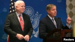 U.S. Senator Lindsey Graham (R) speaks as compatriot Senator John McCain looks on during a news conference in Cairo, August 6, 2013. 