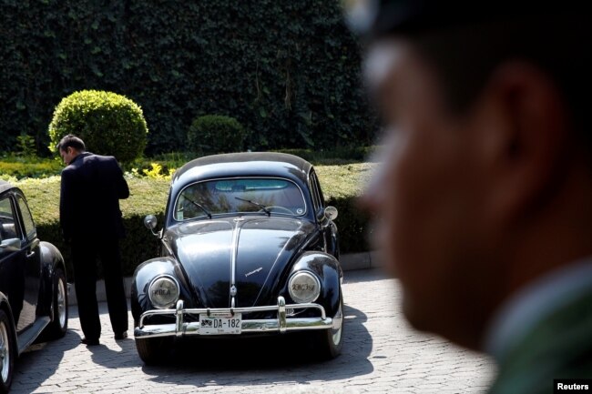 A man stands next to a 1951 Volkswagen, part of the fleet of vehicles seized by the government from politicians and organized crime as part of an auction in Mexico City, May 21, 2019.