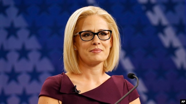 FILE - U.S. Rep. Kyrsten Sinema, D-Ariz., goes over the rules in a television studio prior to a televised debate with U.S. Rep. Martha McSally, R-Ariz., in Phoenix, Oct. 15, 2018.