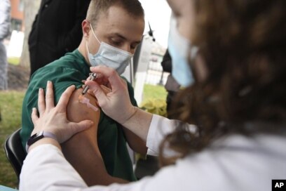 Colleen Teevan, Manajer Klinik Farmasi Sistem di Hartford HealthCare, menyuntikkan vaksin COVID-19 produksi Pfizer-BioNTech kepada petugas kesehatan Connor Paleski di luar Rumah Sakit Hartford di Hartford, Connecticut, 14 Desember 2020,. (Foto: AP / Jessica Hil