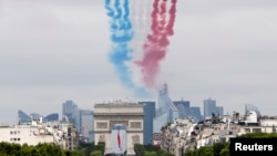 FILE - Nine alphajets from the Patrouille de France release France's national colors trail as they fly above the Arc de Triomphe and the Champs-Elysees avenue during the traditional Bastille Day military parade in Paris July 14, 2014. 