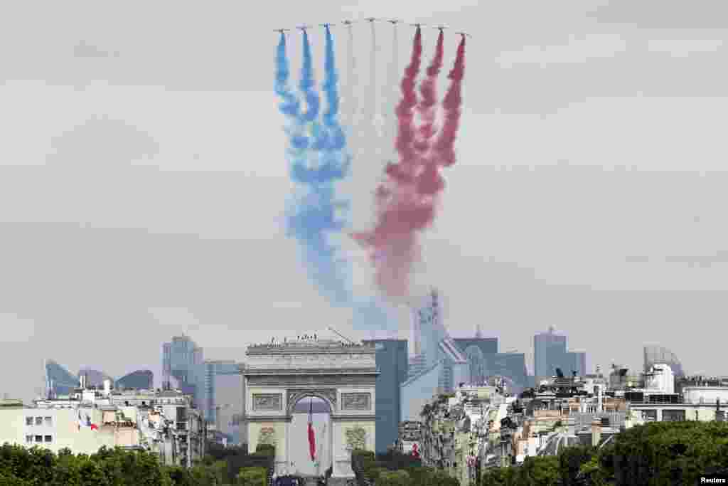 Nine alphajets from the French Air Force Patrouille de France release a trail of national colors as they fly above the Arc de Triomphe and the Champs-Elysees during the annual Bastille Day military parade in Paris, July 14, 2014.