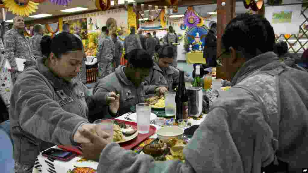 Tentara AS yang bertugas di misi perdamaian yang dipimpin oleh NATO di Kosovo berdoa sebelum menyantap hidangan tradisional Thanksgiving di pangkalan militer Camp Bondsteel, 27 November 2014.