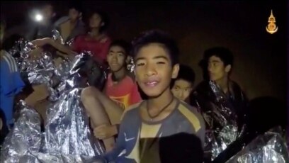 Un niño del equipo de fútbol juvenil menores de 16 años atrapados en una cueva en Tham Luang, Tailandia, envuelto en una frazada, reacciona a la cámara. Imagen tomada de un video el 3 de julio de 2018.