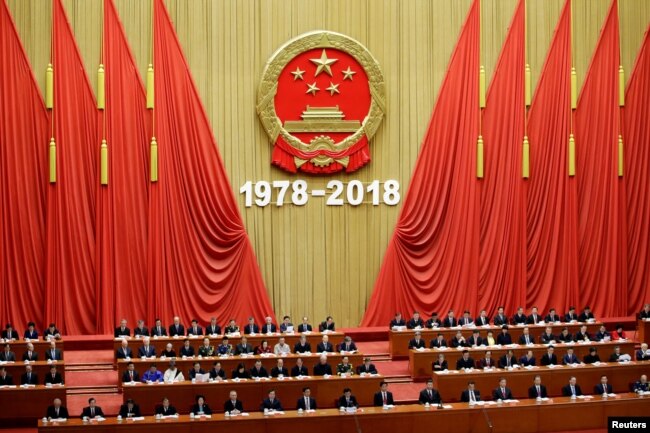 FILE - Chinese President Xi Jinping and others attend an event marking the 40th anniversary of China's reform and opening up at the Great Hall of the People in Beijing, China, Dec. 18, 2018.