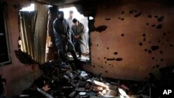 FILE - Kashmiri villagers inspect a house damaged during a gun battle between Indian soldiers and suspected militants in Dadsar on the outskirts of Srinagar, Indian-controlled Kashmir.