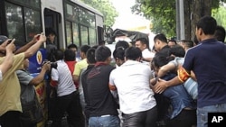 Vietnamese policemen bring protesters onto a bus after breaking up an anti-China demonstration in Hanoi, Vietnam, Sunday, Aug. 21, 2011