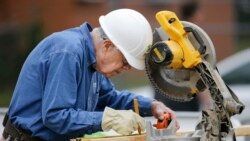 Former president Jimmy Carter measures before making a cut with a miter saw at a Habitat for Humanity building site, Nov. 2, 2015, in Memphis, Tennessee.
