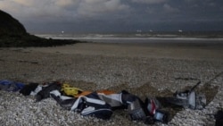 FILE- Life jackets, sleeping bags and damaged inflatable small boat lie on the shore in Wimereux, northern France, Nov. 26, 2021 in Calais, northern France.