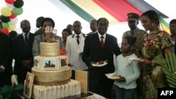 FILE: Zimbabwe President Robert Mugabe (4th R) and first lady Grace Mugabe (2nd R) stand with the presidents birthday cake among guests on the occasion of his 89th birthday celebrations held in his honour at the State House, the eve of his birthday, February 20
