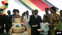 FILE: Zimbabwe President Robert Mugabe (4th R) and first lady Grace Mugabe (2nd R) stand with the president's birthday cake among guests on the occasion of his 89th birthday celebrations held in his honour at the State House, the eve of his birthday.