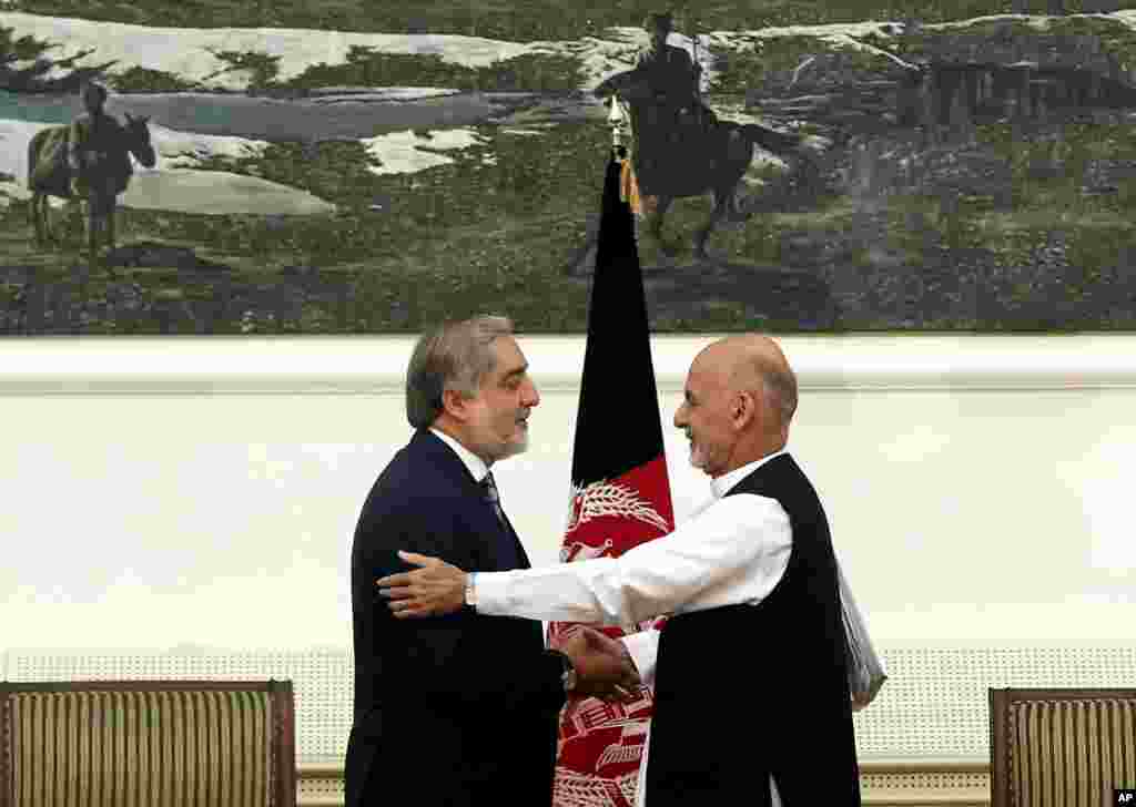 Abdullah Abdullah and Ashraf Ghani Ahmadzai shake hands after signing a power-sharing deal at the presidential palace in Kabul, Afghanistan, Sept. 21, 2014 