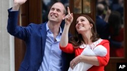 Pangeran William bersama Kate, Duchess of Cambridge, membawa bayi mereka keluar dari rumah sakit St Mary's di London, Inggris hari Senin (23/4). 