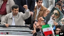 Iranian President Mahmoud Ahmadinejad, clenches his fist from his car, as he attends a rally marking the 32nd anniversary of 1979 Islamic Revolution, Feb 11, 2011