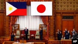 Philippine President Benigno Aquino III, second from left, is applauded by parliament members before addressing the upper house in Tokyo, Wednesday, June 3, 2015. 