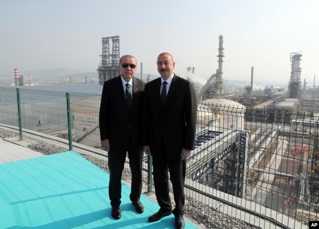 Turkish President Recep Tayyip Erdogan, left, poses for photos with Azerbaijan's President Ilham Aliyev, right, following the inauguration of a new oil refinery at Aliaga, near Izmir, Turkey, Oct. 19, 2018.