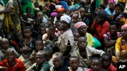 Des réfugiés qui ont fui la violence et les tensions politiques au Burundi attendent de monter à bord d'un navire de l'ONU, à Kagunga sur le lac Tanganyika, le samedi 23 mai 2015. (AP Photo / Jerome Delay, File)