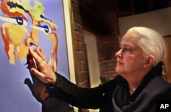 FILE -- Former rock singer Grace Slick touches her painting of the late rock star Jimi Hendrix Nov. 16, 2000, at the Artrock gallery in San Francisco.