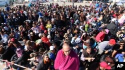 FILE - The long-running conflict in Syria, and other countries plagued by war and poverty, has fed a massive migration to western Europe. Migrants wait for buses in Nickelsdorf, Austria, after crossing from Hungary, Sept. 21, 2015.