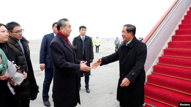资料照片:中国国务委员兼外交部长王毅在北京首都国际机场迎接柬埔寨首相洪森。(2020年2月5日)