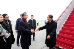 Chinese State Councilor and Foreign Minister Wang Yi welcomes Cambodian Prime Minister Hun Sen as he arrives at the Beijing Capital International Airport in Beijing, China February 5, 2020.