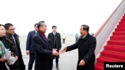 Chinese State Councilor and Foreign Minister Wang Yi welcomes Cambodian Prime Minister Hun Sen as he arrives at the Beijing Capital International Airport in Beijing, China February 5, 2020.