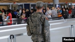 A U.S. Army Specialist monitors the security line at John F. Kennedy international Airport in the Queens borough of New York, June 29, 2016.