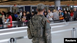 Un militaire veillant sur la ligne d'embarquement à l'aéroport John F. Kennedy international de New York, 29 juin, 2016.