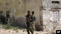 Government troops patrol a neighborhood destroyed by years of fighting in Mogadishu, January 10, 2008