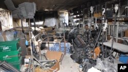 In this photo released by the Syrian official news agency, SANA, a damaged equipment storage room of the Ikhbariya TV station is seen after it was attacked by gunmen in the town of Drousha, south of Damascus, June 27, 2012. 