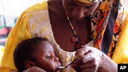 Mother feeding her severely malnourished daughter at center in Niger run by CONCERN and supported by WFP in October 2010.