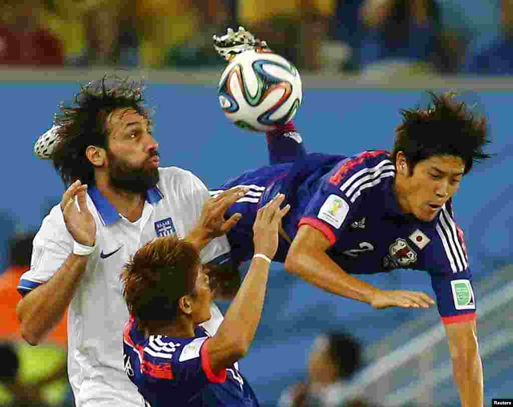 Japan's Atsuto Uchida is fouled by Greece's Giorgios Samaras during their 2014 World Cup Group C soccer match at the Dunas arena in Natal, June 19, 2014.