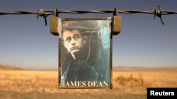 FILE PHOTO: A portrait of U.S. actor James Dean hangs from a fence near the intersection of Highways 46 and 41 near Cholame, California September 30, 2005.