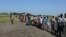 FILE - Hundreds of people wait in line in August 2015 in the town of Koch in South Sudan to receive food aid. Aid agencies stopped deliveries to Koch in May, after a sharp surge in violence there.