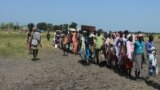 Hundreds of people wait in line in the town of Koch in South Sudan's Unity state to receive food aid from the World Food Program on Friday, Sept. 25, 2015. Aid agencies resumed deliveries to the war-torn area after a four-month break precipitated by an uptick in fighting. 