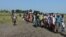 Hundreds of people wait in line in the town of Koch in South Sudan's Unity state to receive food aid from the World Food Program on Friday, Sept. 25, 2015. Aid agencies resumed deliveries to the war-torn area after a four-month break precipitated by an uptick in fighting. 