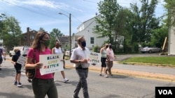 Julia Young, marching with her father Malcolm, in an Arlington, Virginia, “Say Their Names” protest against police brutality. (VOA/Carolyn Presutti)