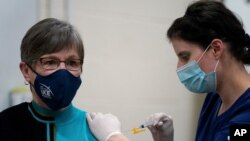 La enfermera de salud pública Lisa Horn inyecta la vacuna contra la COVID-19 a la gobernadora demócrata de Kansas, Laura Kelly, el miércoles 30 de diciembre de 2020, en Topeka, Kansas.