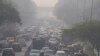 FILE - Commuters drive amidst morning haze and toxic smog in New Delhi, India, Nov. 17, 2021. 